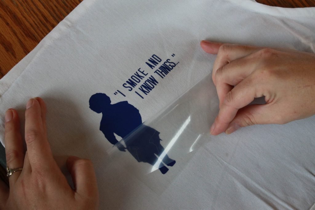 Hands peeling back transfer paper for Everyday Iron-on vinyl