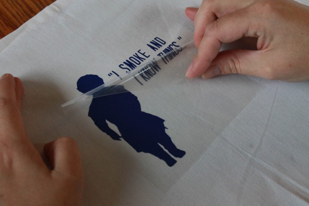 Hands peeling back transfer paper for Everyday Iron-on vinyl