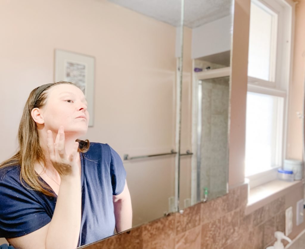 woman applying vitamin a Beauté Pacifique cream in mirror