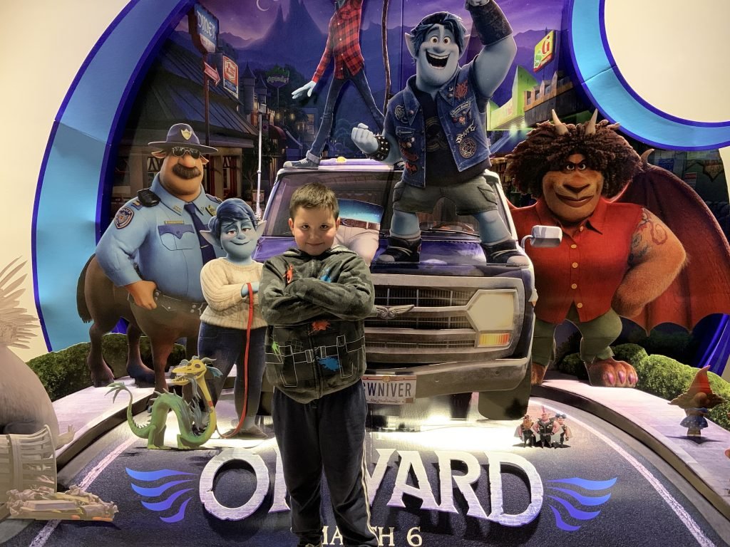 Breton standing in front of Onward photo board