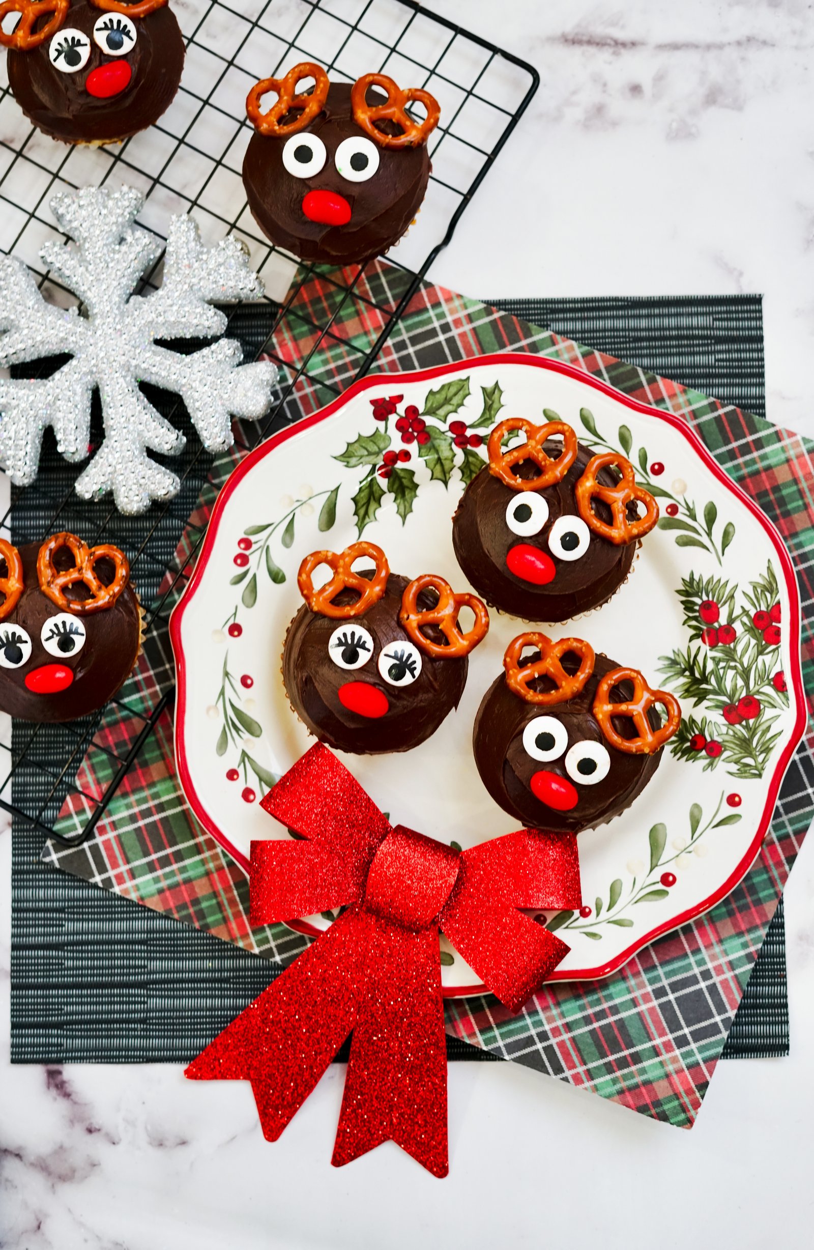 Horizontal rudolph cupcakes on a plate and cooling rack with chocolate icing