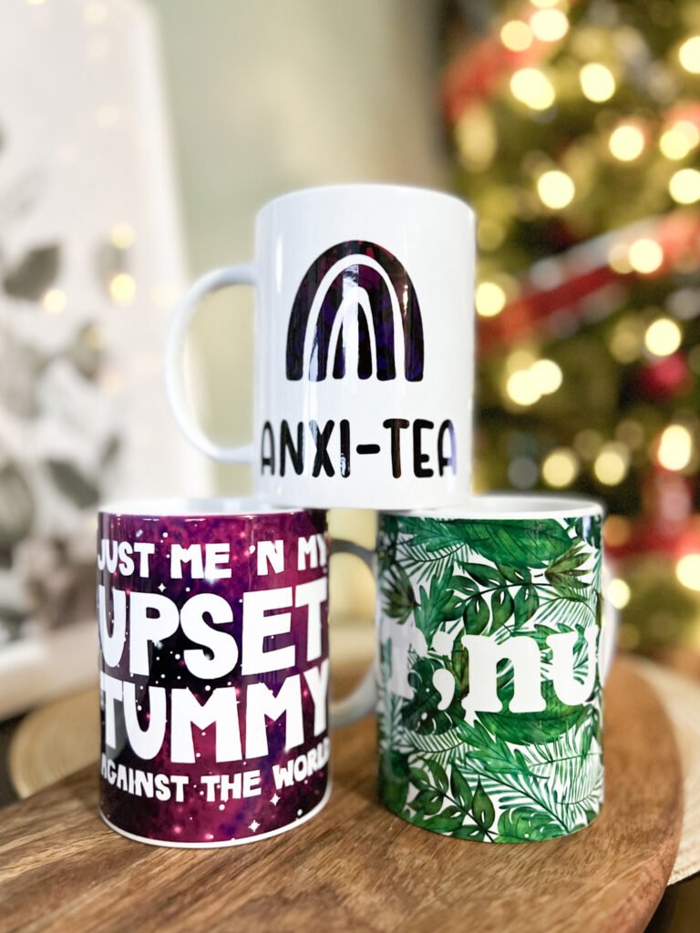 Cricut Mug Press mugs stacked in a pyramid including Anti-Tea, Just me and my upset tummy against the world