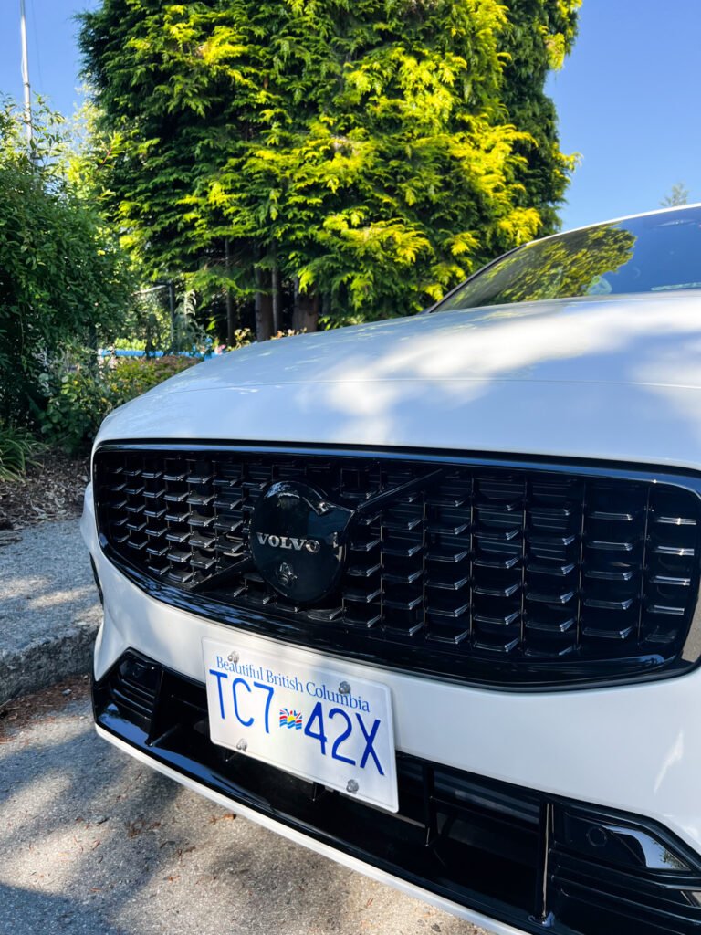 Volvo S60 Recharge T8, White, parked in front of a green leafy tree