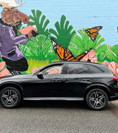 Black Mercedes 2023 GLC 300 in front of painted wall with butterflies